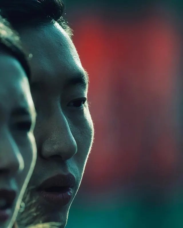 Close-up Portrait with Red and Teal Lighting, photographic, dark-mode, high-contrast