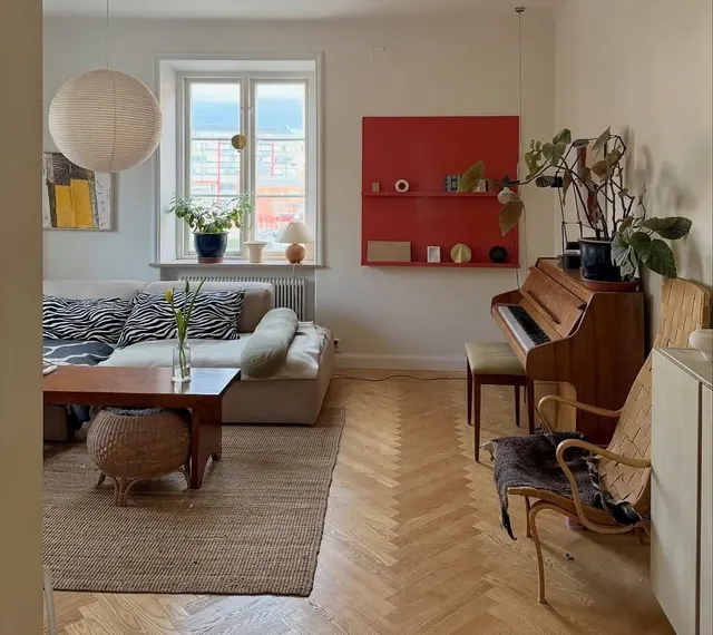 Scandinavian living room with red accent wall, minimal, organic, warm