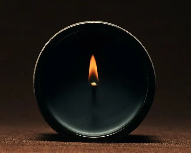 Ceramic candle with single bright flame, minimal, organic, dark