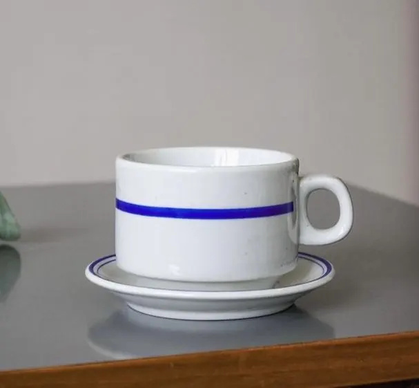 Minimalist ceramic cup and saucer with single blue band, minimal, flat, light