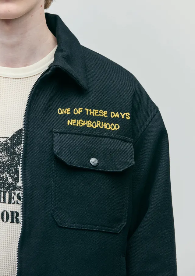 Utilitarian overshirt with gold embroidered branding, minimal, technical, dark