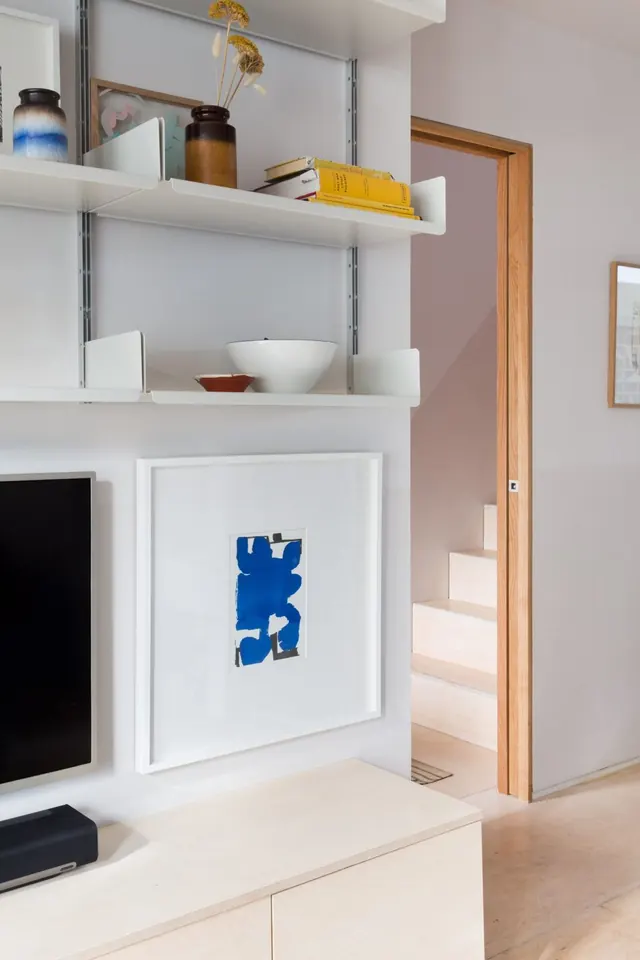 Warm minimalist interior with open shelving and framed blue abstract art, minimal, organic, light