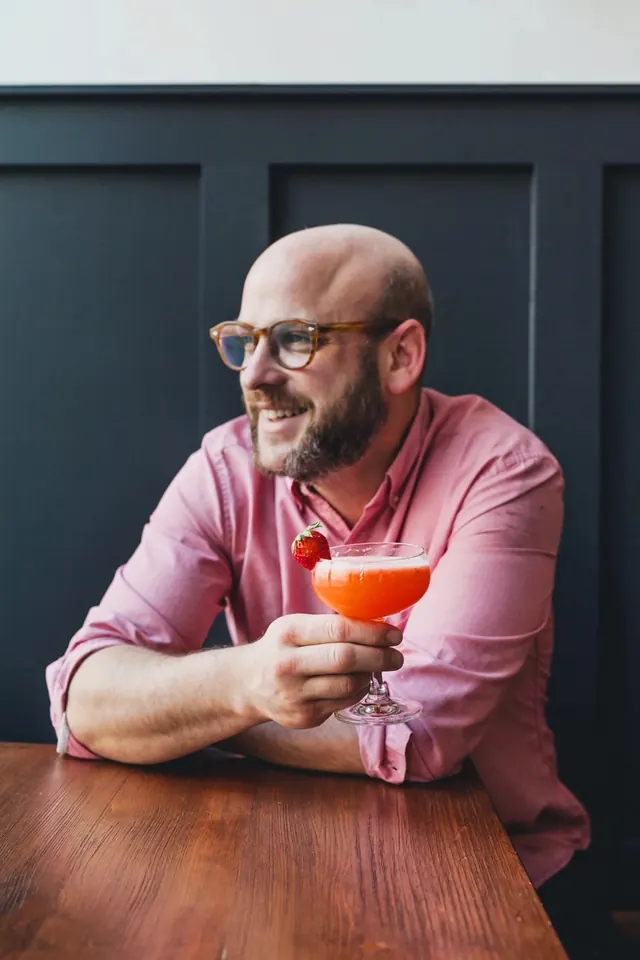 Man enjoying a cocktail, photographic, warm