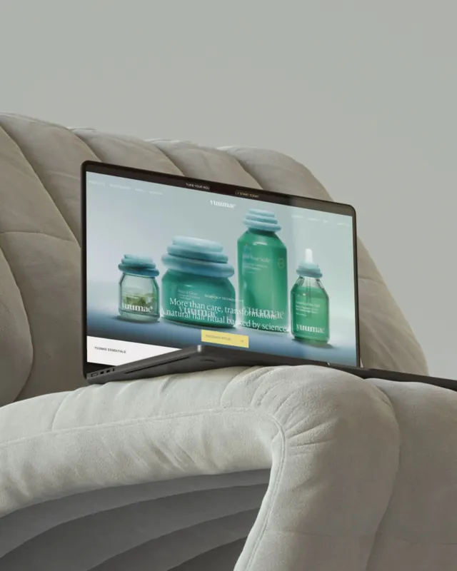 Yuumac skincare product website on curved laptop in lifestyle setting, minimal, photographic, light