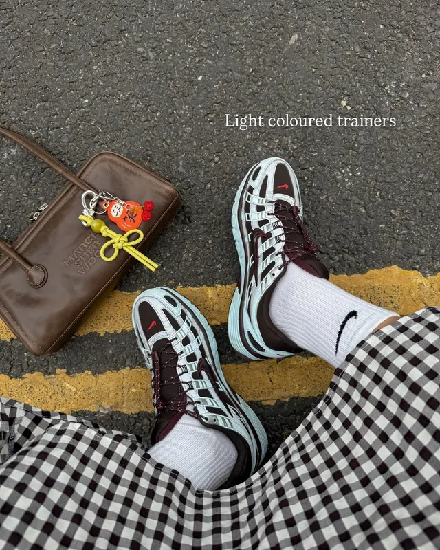 Streetwear flat lay with trainers and leather goods, photographic, minimal, earthy