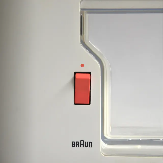 Braun appliance detail: red indicator button, minimal, technical, light