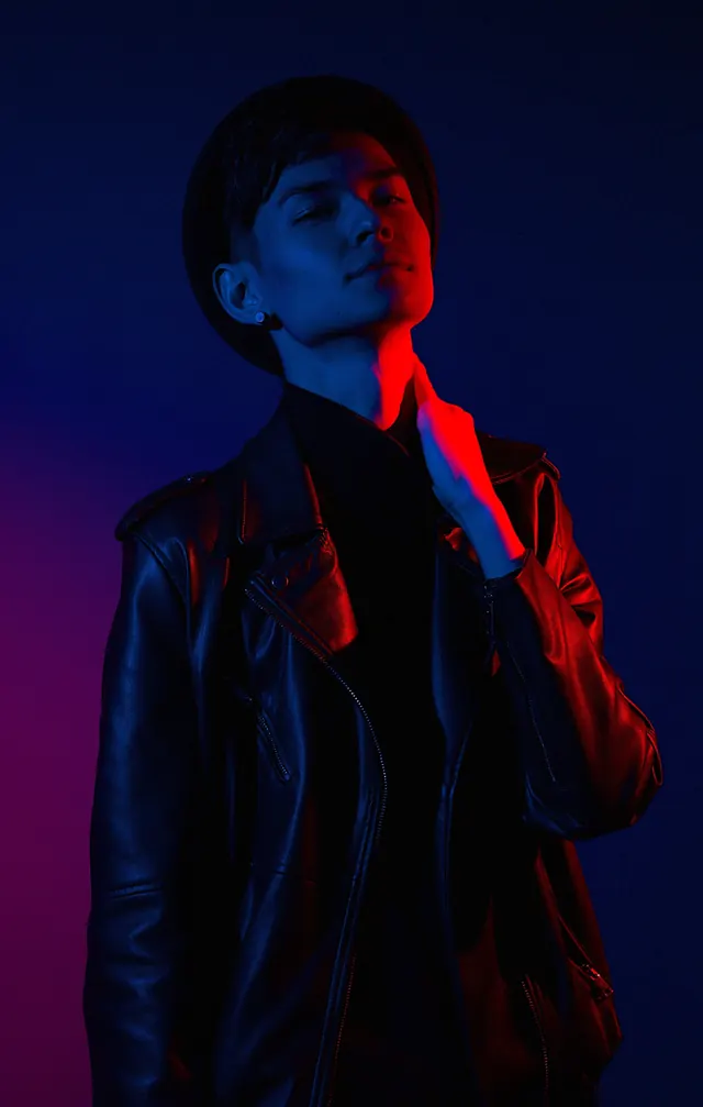 Portrait of a person in leather jacket with blue and red lighting, dark-mode, photographic, dark