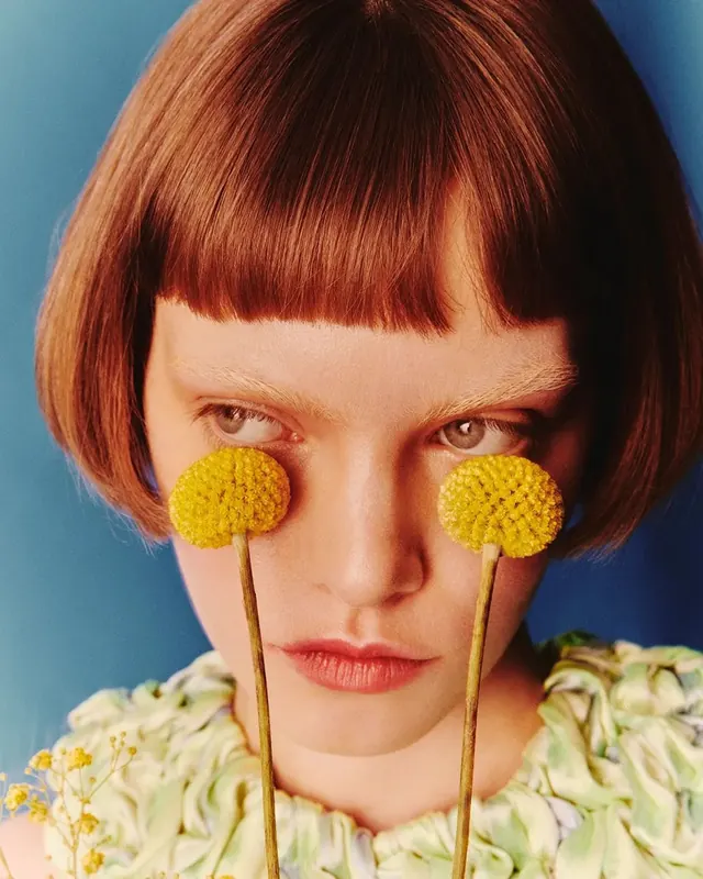 Portrait of a woman with yellow pom-poms, editorial, organic, vibrant