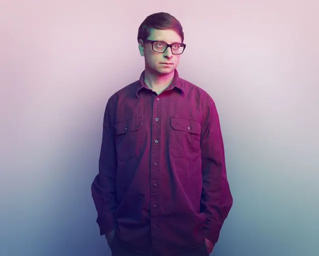 Portrait of a man in a purple shirt, minimal, photographic, vibrant