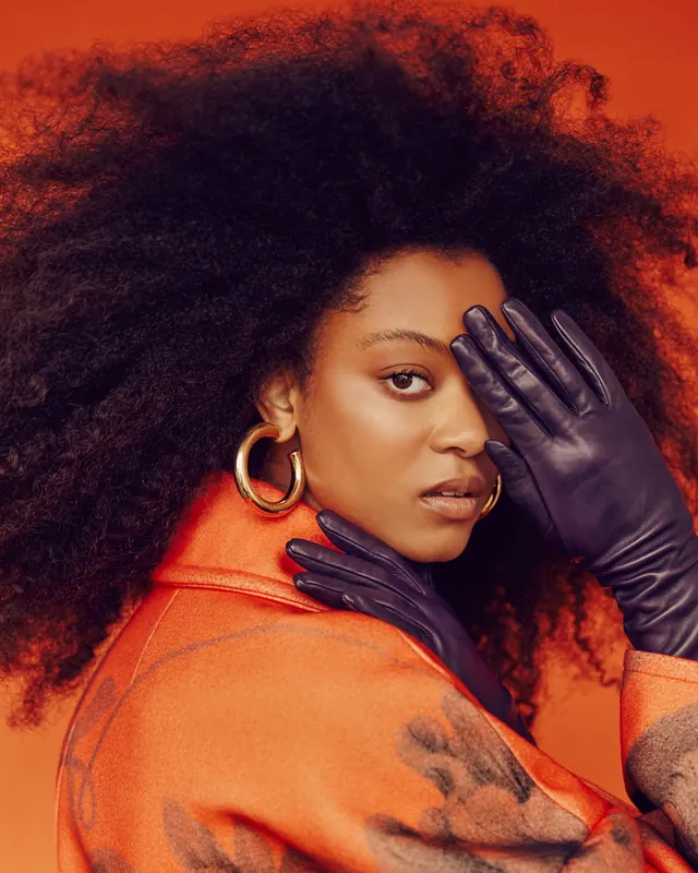 Portrait of a woman in orange and black, photographic, vibrant