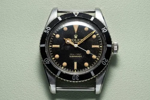 Vintage dive watch face-on product shot, minimal, photographic, light