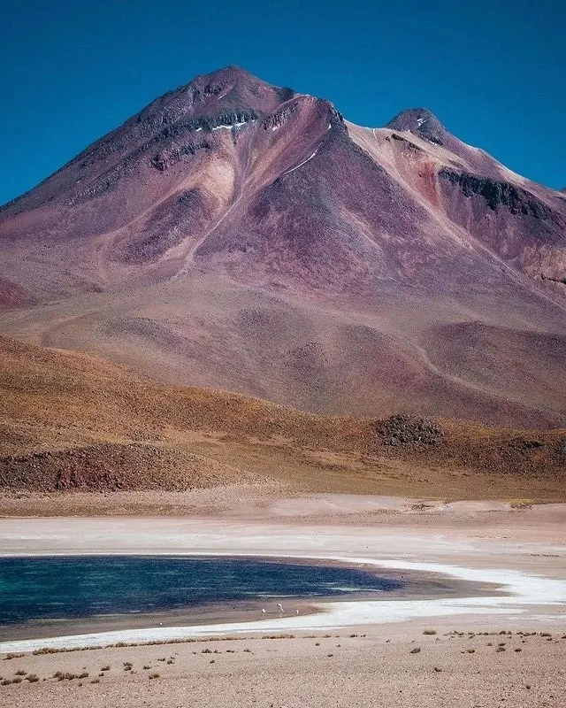 Volcanic landscape with mineral-toned lake, photographic, minimalist, vibrant