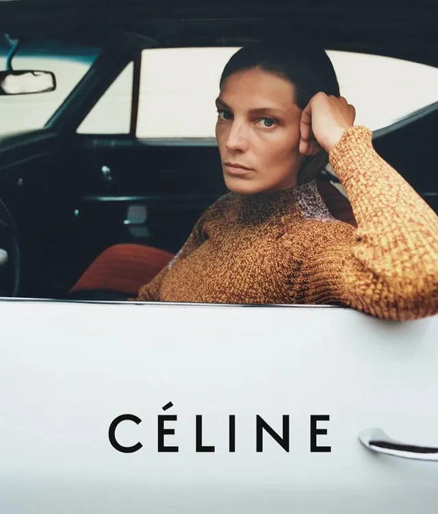 Woman in rust-toned sweater in car portrait, photographic, editorial, warm