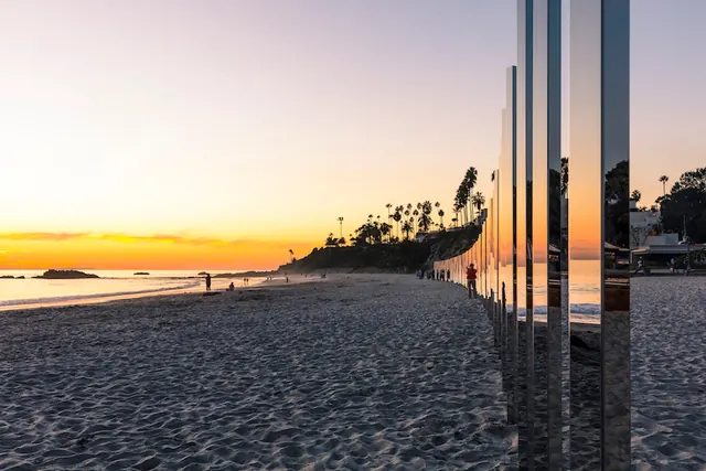 Coastal sunset photograph with architectural reflection, photographic, minimal, warm