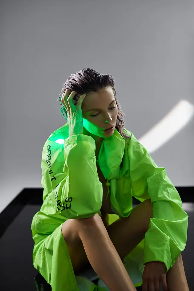 Bright neon yellow raincoat studio portrait, photographic, playful, neon