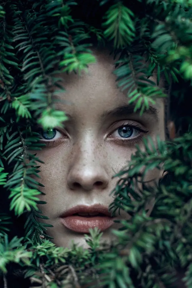 Portrait of a face obscured by ferns, photographic, organic, dark