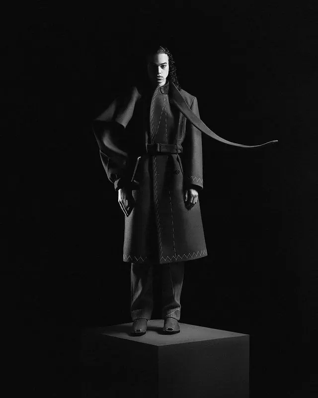 Low-key fashion editorial with belted wool coat, dark-mode, editorial, dark