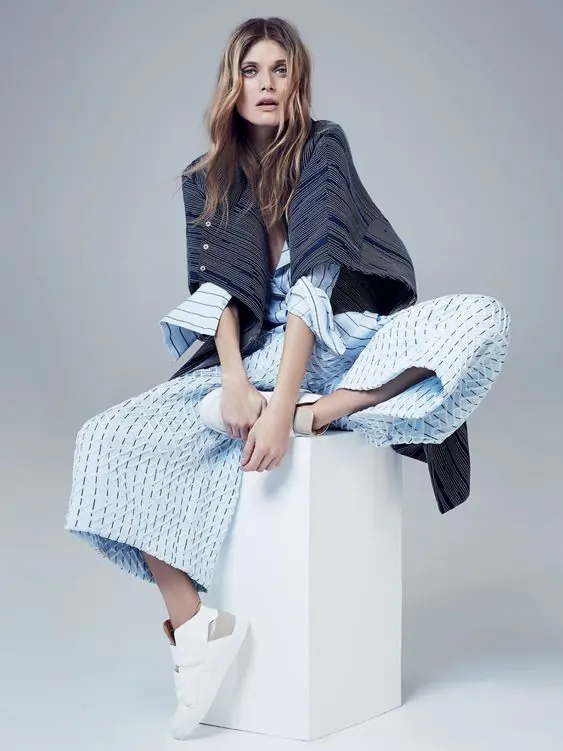 Editorial fashion portrait with geometric layered clothing, minimal, photographic, light