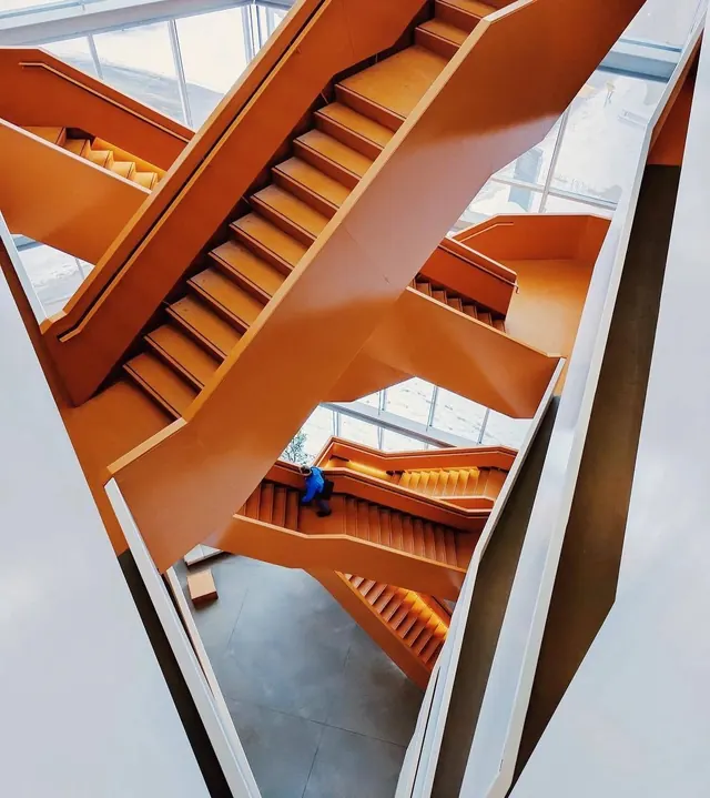 Overhead orange stairwell architectural study, photographic, geometric, warm