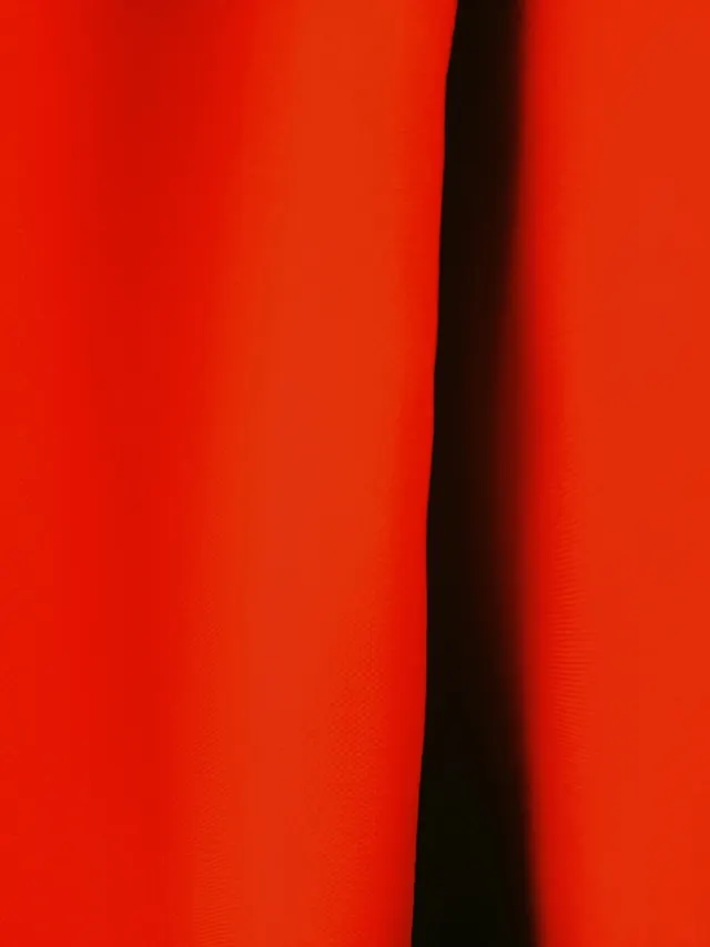 Macro shot of red fabric fold and shadow gap, abstract, minimal, vibrant