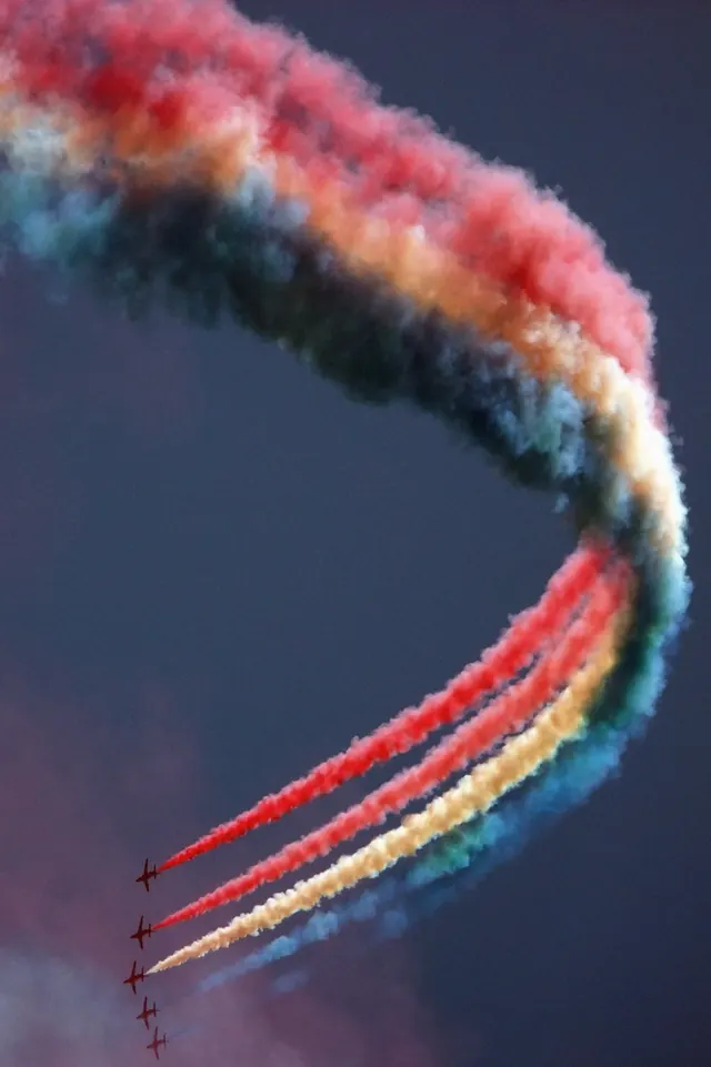 Acrobatic jets with colored smoke trails, photographic, vibrant
