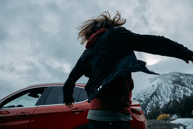 Woman with windswept hair at mountain landscape, photographic, cool