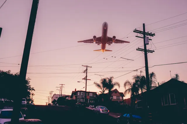 Passenger aircraft at takeoff against pink dusk sky, photographic, minimalist, warm