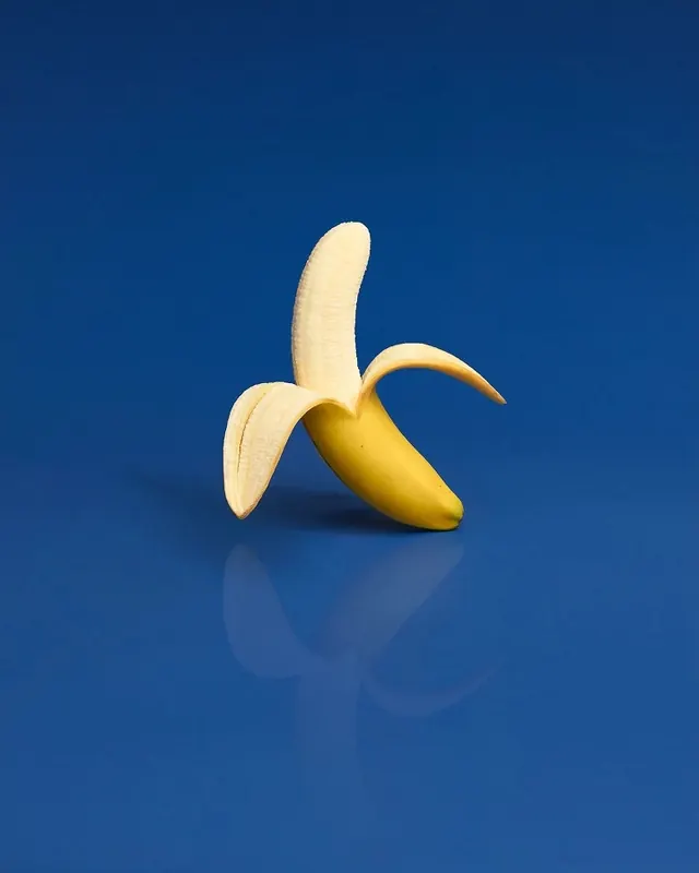 Banana still life against cobalt background, photographic, minimal, vibrant