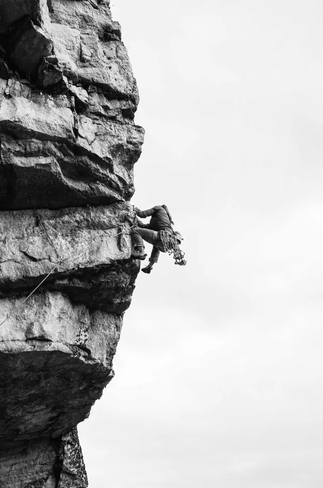 Rock climber silhouette on limestone overhang, photographic, minimal, monochrome