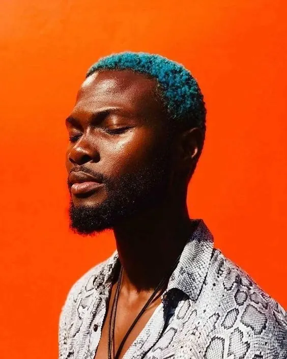 Portrait with blue hair against orange backdrop, photographic, minimal, vibrant