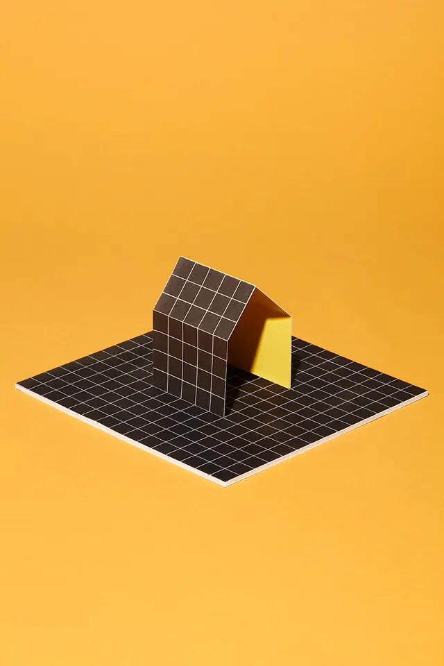 Paper house model on grid base against yellow, minimal, geometric, vibrant