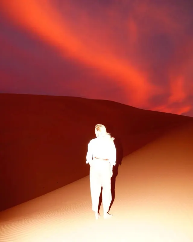Figure in desert landscape illustration, illustrated, gradient-heavy, warm