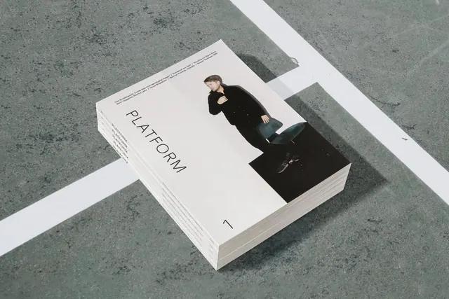 Minimalist publication mockup "PLATFORM" on concrete surface, minimal, swiss, light