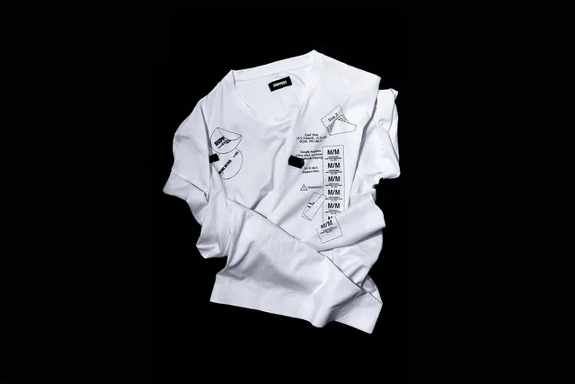 White long-sleeve graphic t-shirt flat lay on black, minimal, monochrome, dark