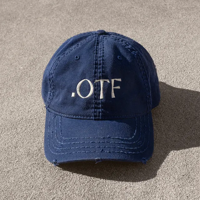 Navy denim cap with embroidered 'OTF' branding, minimal, photography, dark
