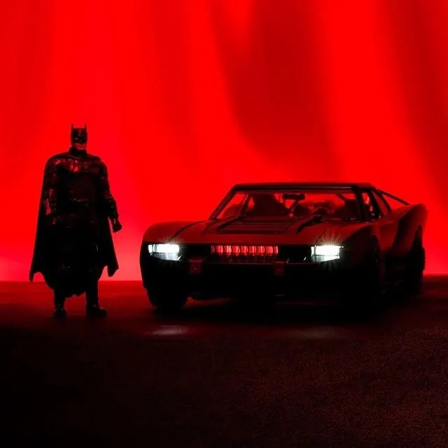 Batman figure and Batmobile toy photograph, dark-mode, cinematic, dark
