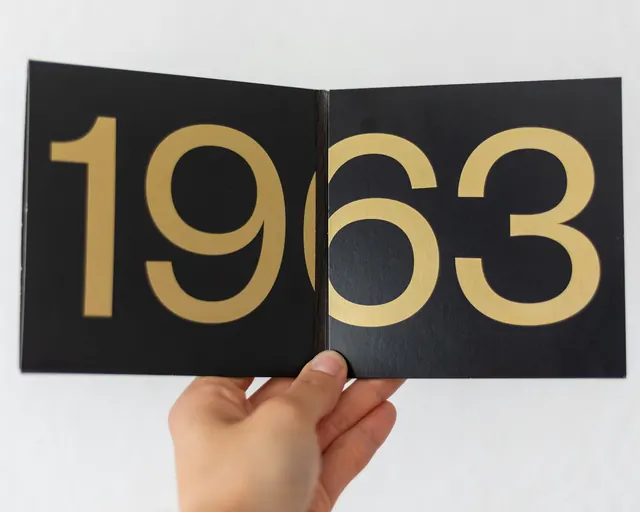 Gold numbers on black hardcover spread, luxury, editorial, dark