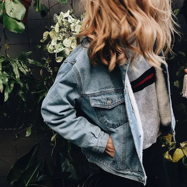 Woman in denim jacket with layered casual styling, photographic, editorial, warm