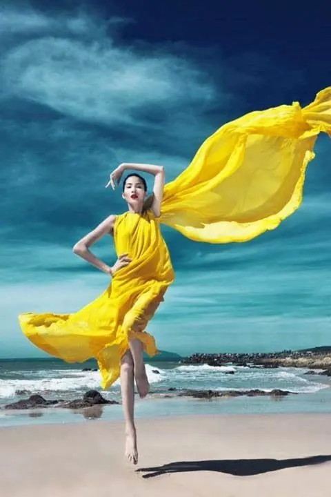 Fashion editorial – yellow flowing gown at beach, photographic, editorial, vibrant