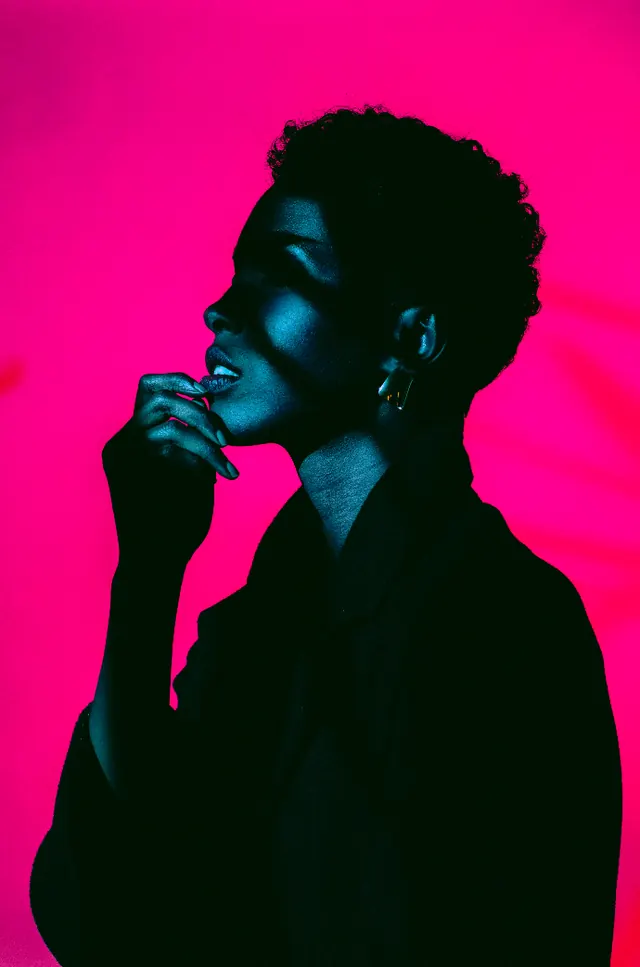 Teal-lit profile on magenta ground, minimal, photographic, vibrant