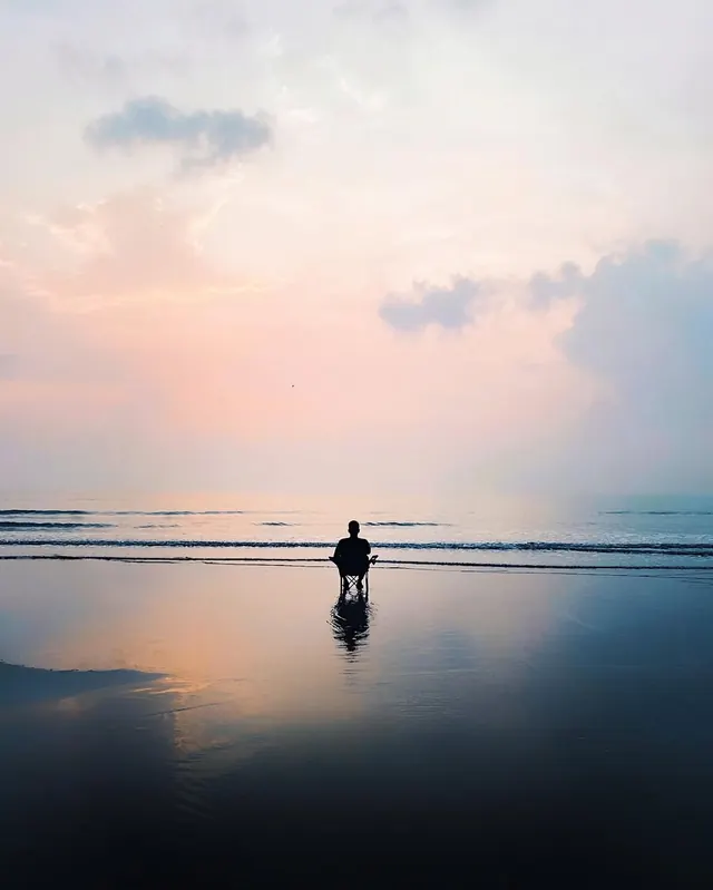 Silhouette on wet beach at dawn, minimal, photographic, pastel