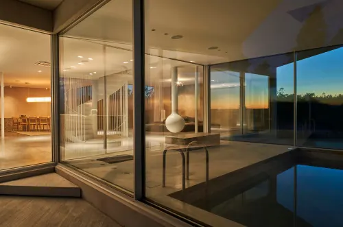 Glass house at blue hour with pool, minimal, photographic, cool