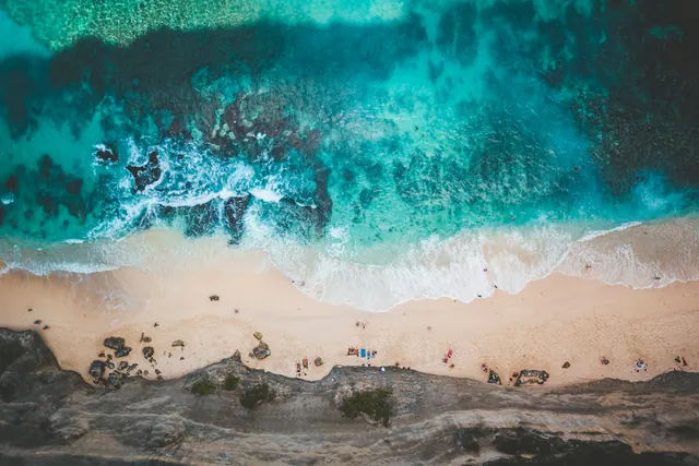 Aerial cliff beach and reef water, photographic, minimal, vibrant