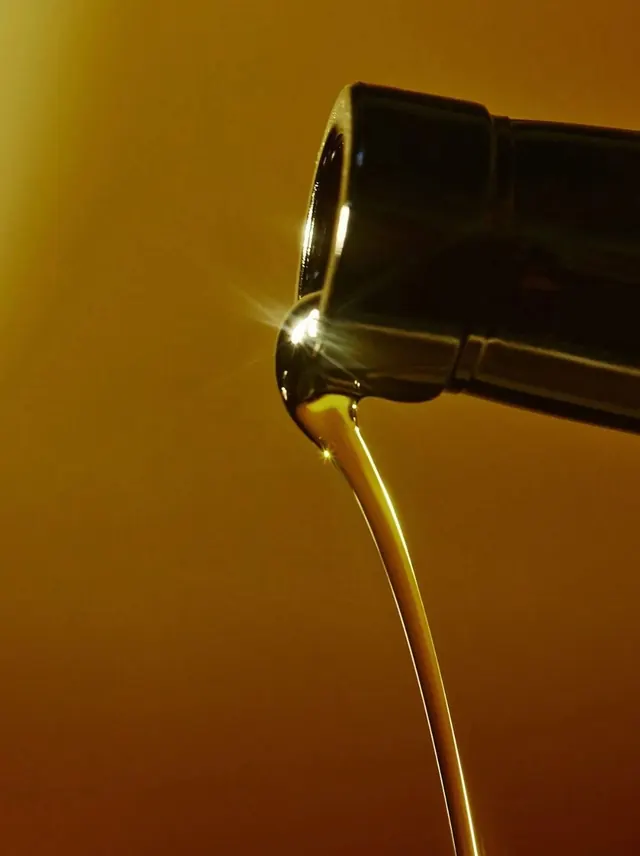 Oil pour product shot, photographic, product-focused, warm
