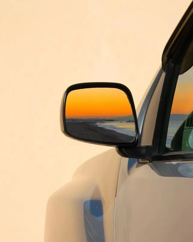 Car mirror sunset reflection, photographic, organic, warm