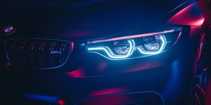 Luxury car headlight with neon blue and magenta lighting, photographic, technical, dark