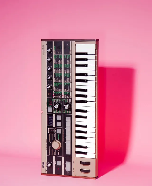 Music production synthesizer keyboard on hot pink background, photographic, flat, vibrant