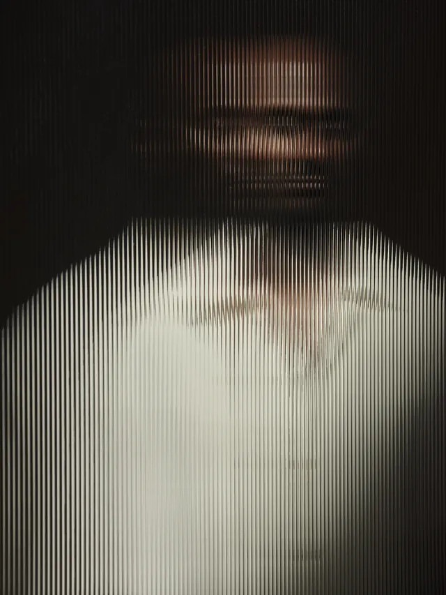 Ribbed glass portrait distortion, editorial, photographic, dark