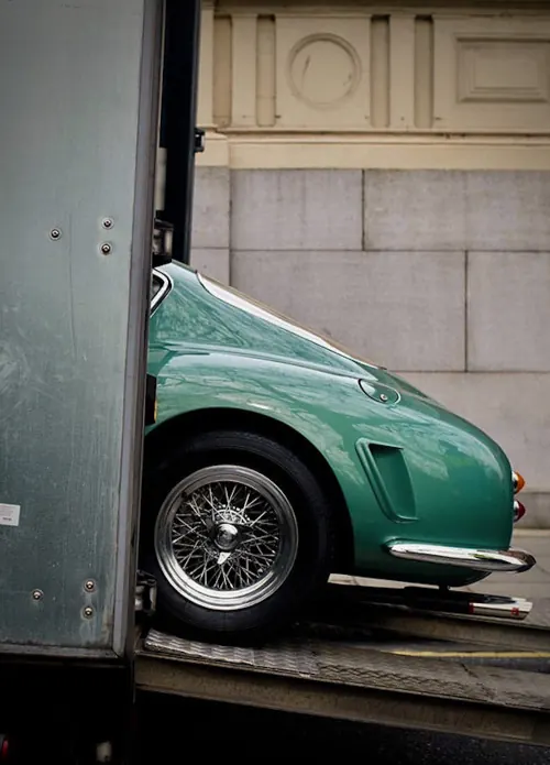Teal Ferrari on loading ramp, editorial, photographic, muted