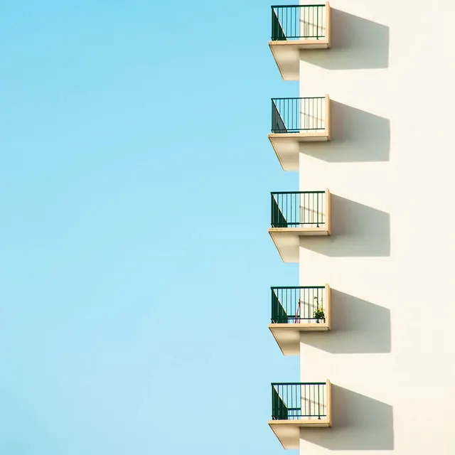 Stacked balconies on white facade, minimal, swiss, light